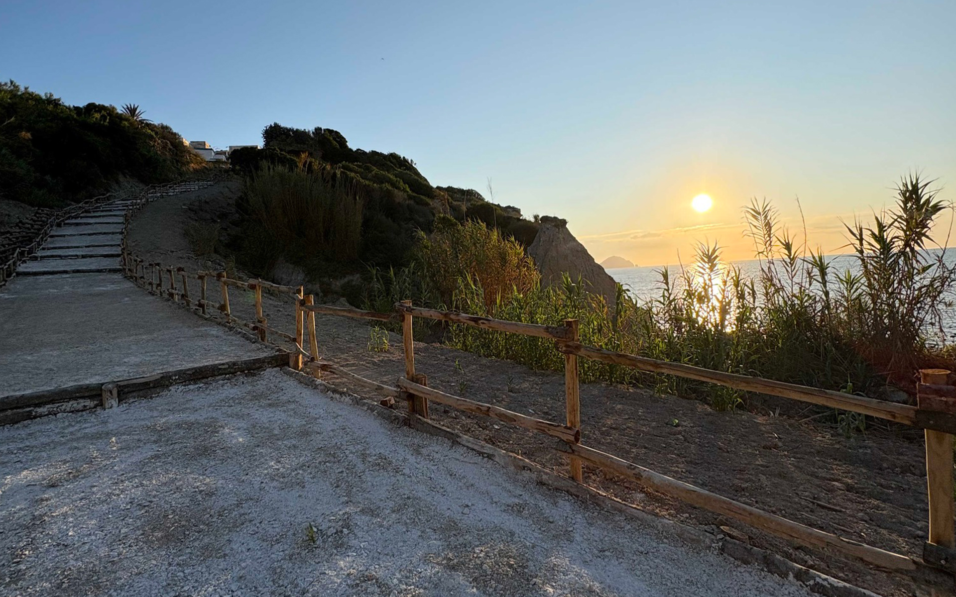 Sentiero costiero di Ponza al tramonto, luce calda e vista sul mare